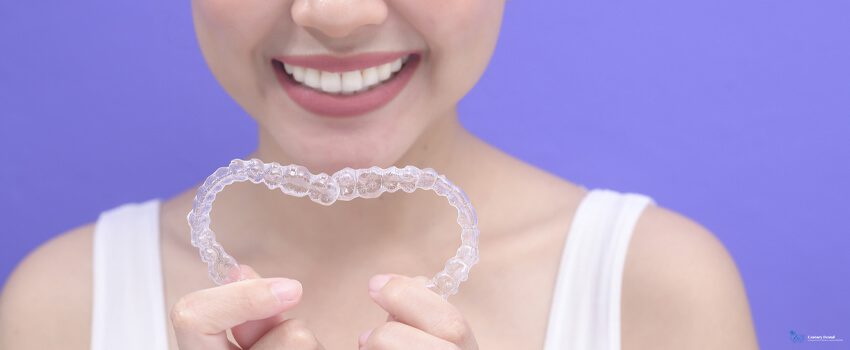 Century-Dental-Young-smiling-woman-holding-invisalign-braces